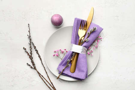 Stylish table setting for Easter celebration on light background