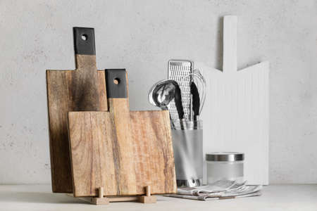 Wooden cutting boards and kitchen utensils on light backgroundの写真素材