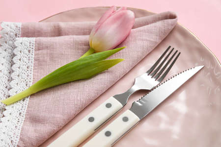 Elegant table setting and flower on pink background, closeup