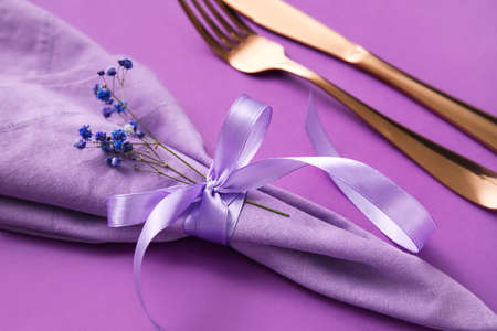 Simple table setting with flowers on purple background, closeupの写真素材