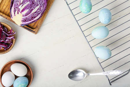Homemade dyed Easter eggs and purple cabbage on white wooden backgroundの写真素材