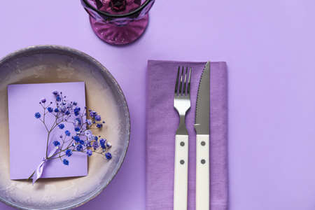 Simple table setting with flowers on purple background