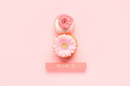 Composition with beautiful flowers, ribbons and word MARCH on pink background. International Women's...