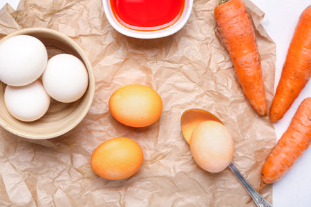 Natural dyed Easter eggs and carrots on parchmentの写真素材