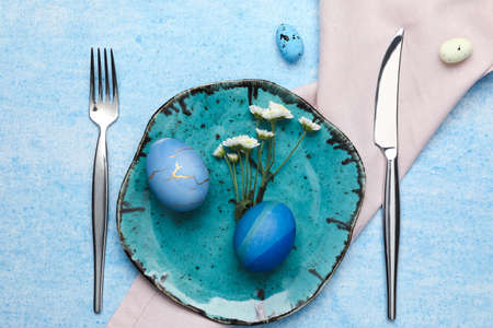 Stylish Easter table setting on blue backgroundの写真素材