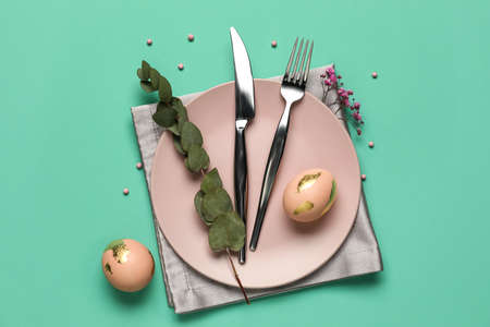 Stylish Easter table setting on green background