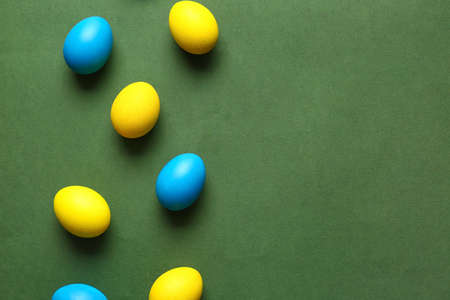 Blue and yellow Easter eggs on color backgroundの写真素材