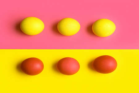 red and yellow easter eggs on color backgroundの写真素材