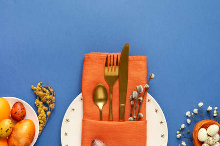 Beautiful table setting for Easter celebration on blue background