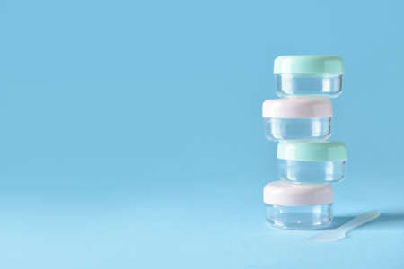 Set of empty travel cosmetic jars on blue background
