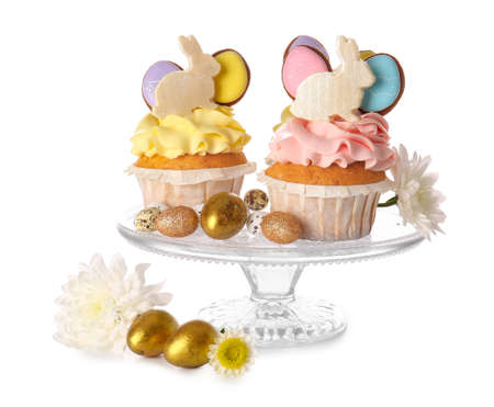 Stand with tasty Easter cupcakes and eggs on white background
