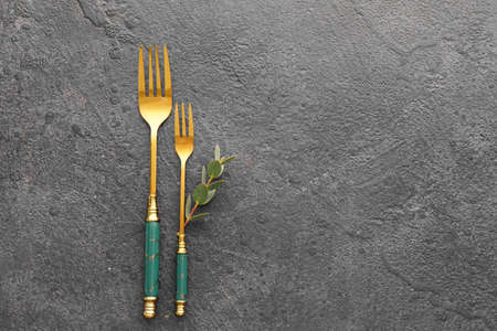 Stylish stainless steel forks on black background