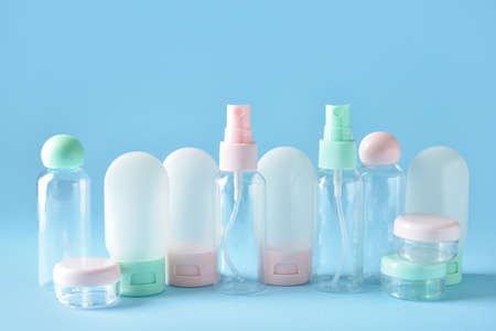 Set of empty travel cosmetic bottles and jars on blue backgroundの写真素材