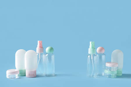 Set of empty travel cosmetic bottles and jars on blue backgroundの写真素材