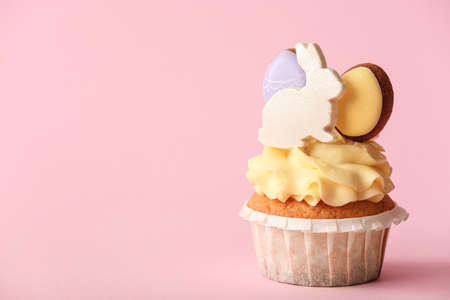 Tasty Easter cupcake on pink background, closeup