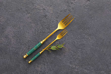 Stylish stainless steel forks on black background