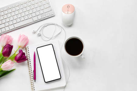 Composition with gadgets, cup of coffee and tulip flowers on light background