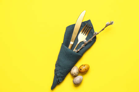 Beautiful cutlery for Easter celebration on yellow background