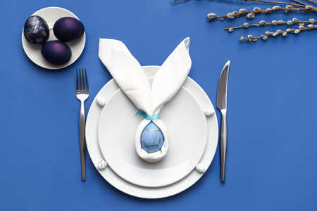 Beautiful table setting for Easter celebration on blue background
