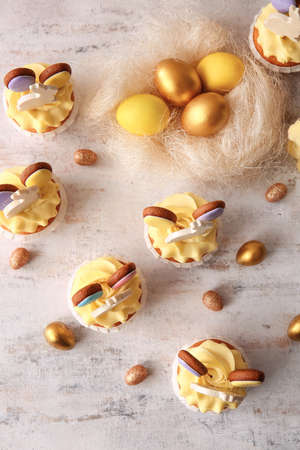 Tasty Easter cupcakes with eggs on light background