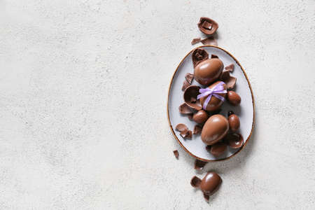 Plate with chocolate Easter eggs on light backgroundの写真素材