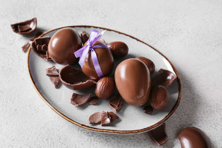 Plate with chocolate Easter eggs on light backgroundの写真素材