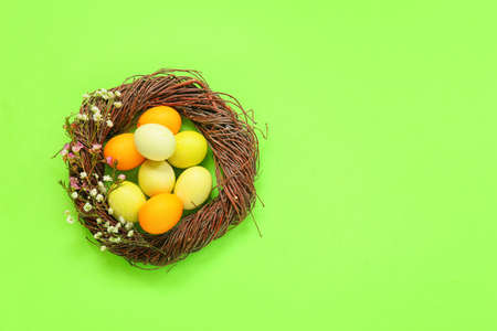Wreath with Easter eggs on green background