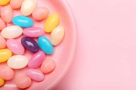 Plate with multicolored jelly beans on color backgroundの写真素材