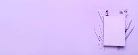 School stationery on lilac background with space for text, top viewの写真素材