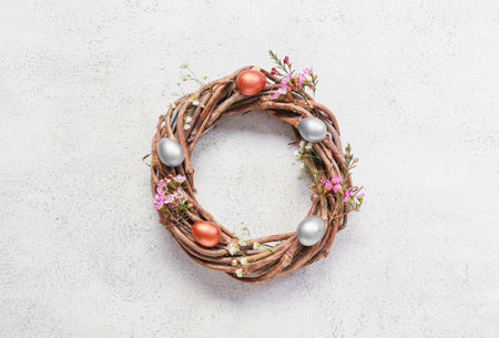 Wreath with Easter eggs on light background