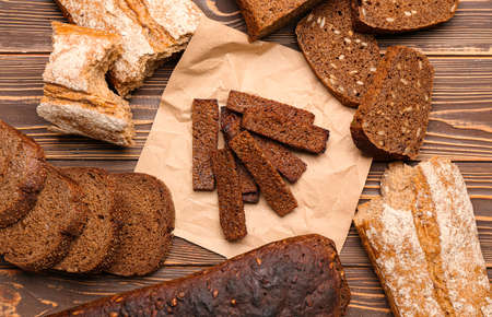 Tasty croutons and bread on wooden background