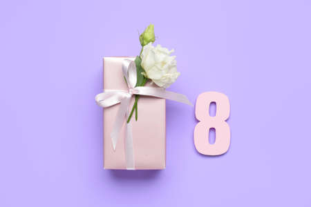 Gift box with flower for International Women's Day on color backgroundの写真素材