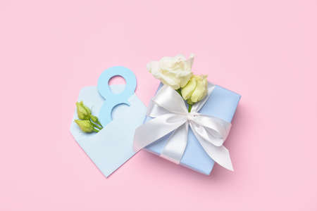 Composition with gift box, flowers and envelope for International Women's Day on color background