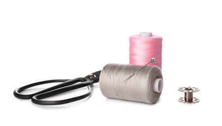 Thread spools ball pin and scissors on white background