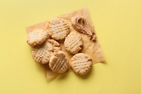 Tasty peanut cookies on yellow background