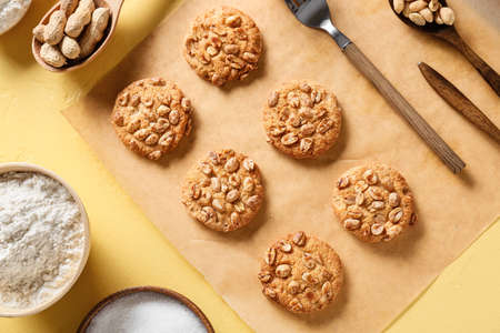 Parchment paper with tasty peanut cookies on yellow backgroundの写真素材