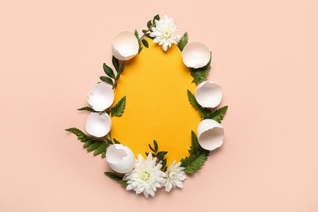 Green leaves with flowers and shell in shape of egg on light backgroundの写真素材