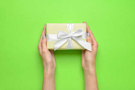 Woman with gift box on color background