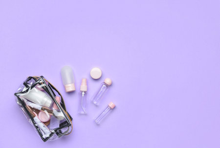Empty travel bottles and bag with cosmetics on lilac backgroundの写真素材