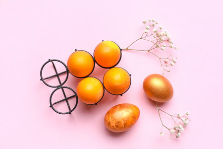 Composition with beautiful Easter eggs and gypsophila flowers on pink backgroundの写真素材
