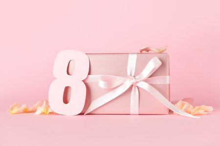 Beautiful gift box for International Women's Day and paper figure 8 on color background