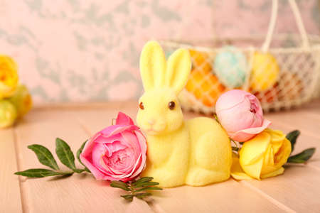 Beautiful Easter bunny and flowers on pink wooden background