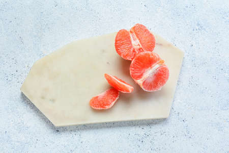 Board with fresh cut grapefruit on light backgroundの写真素材