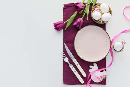 Beautiful Easter table setting with tulip flowers on white background