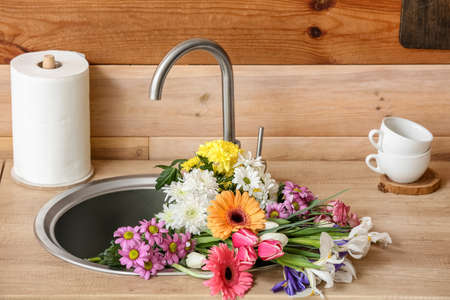 Bouquet of beautiful flowers in kitchen sinkの写真素材