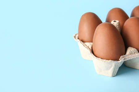 Holder with chocolate Easter eggs on blue background, closeup