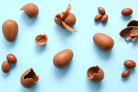 Broken chocolate Easter eggs on blue background