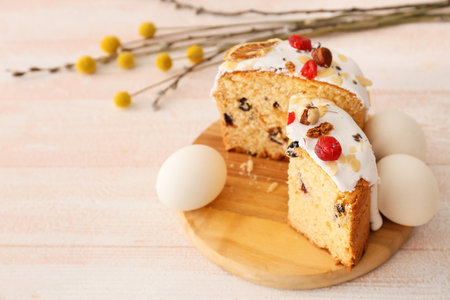Board with delicious Easter cakes and eggs on white wooden background