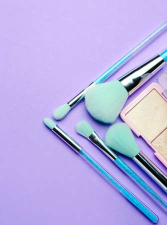 Set of makeup brushes and highlighter on purple backgroundの写真素材
