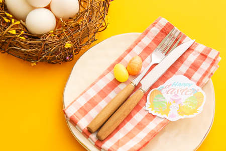 Beautiful table setting for Easter celebration on orange background, closeup
